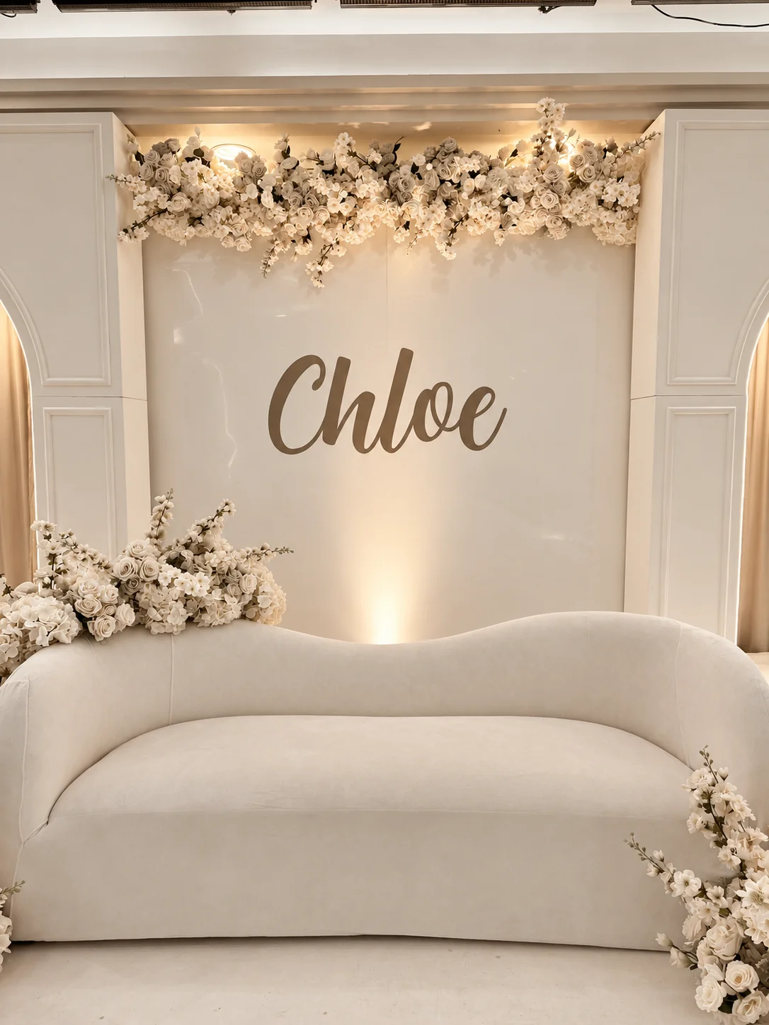 Script name stage lettering in a taupe and ivory colour treatment